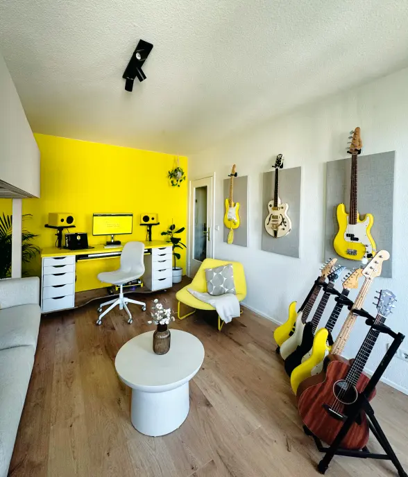 Collection of guitars on wall panels and a multi-guitar stand